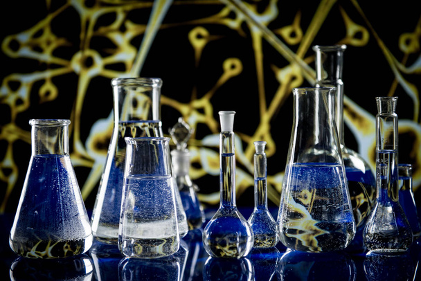 Лабораторное оборудование, много стекла, наполненного красочными жидкостями
 - Фото, изображение