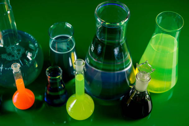 Лабораторное оборудование, много стекла, наполненного красочными жидкостями
 - Фото, изображение