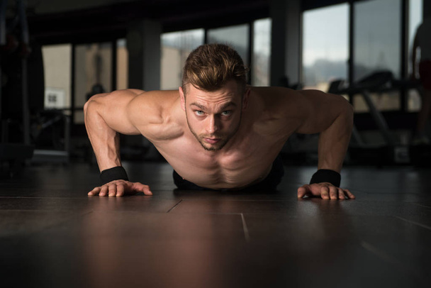 Young Man Doing Press Ups In Gym - 写真・画像