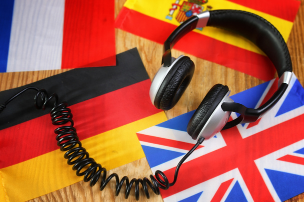 auriculares y bandera del idioma del curso en una mesa
 - Foto, imagen