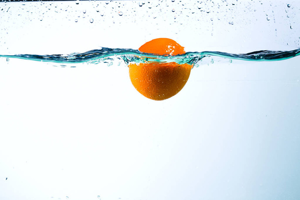 Orange in streams of water on a white background - Foto, immagini