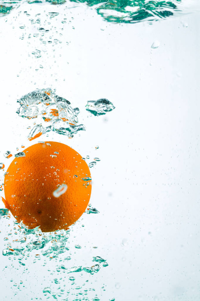 Orange in streams of water on a white background - Fotó, kép