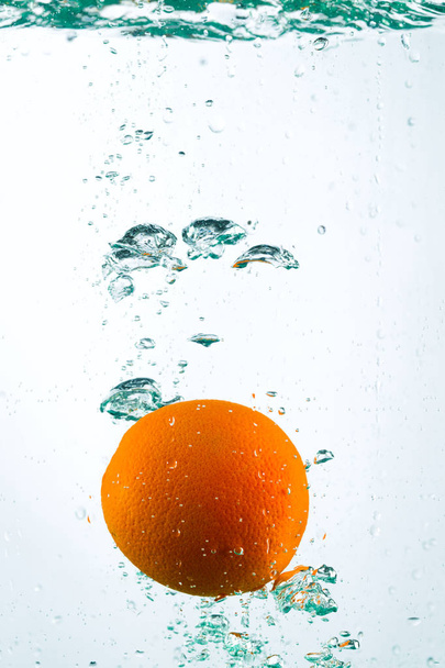Orange in streams of water on a white background - Photo, Image