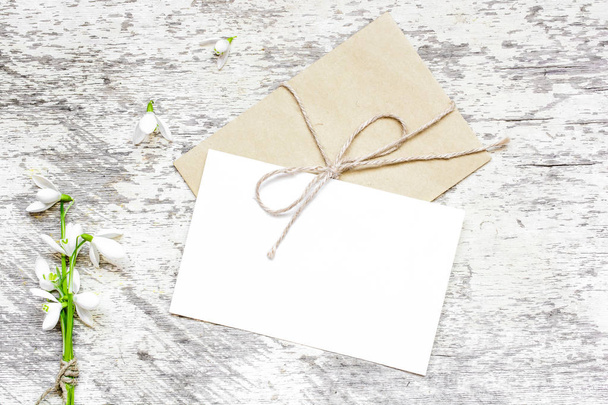 порожня біла вітальна листівка та конверт зі сніговими квітами
 - Фото, зображення