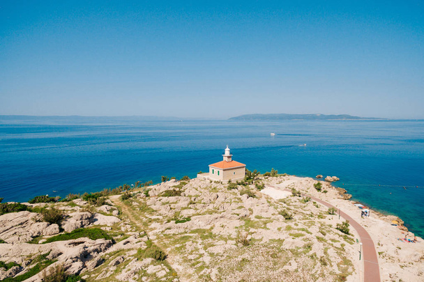 Farol de pedra branca estabelecido na costa no Mar Adriático. Cle...
 - Foto, Imagem