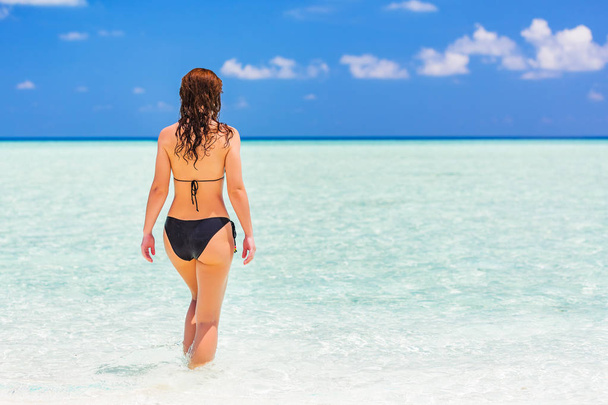 Attractive young woman enjoys Maldivian beach - Foto, afbeelding