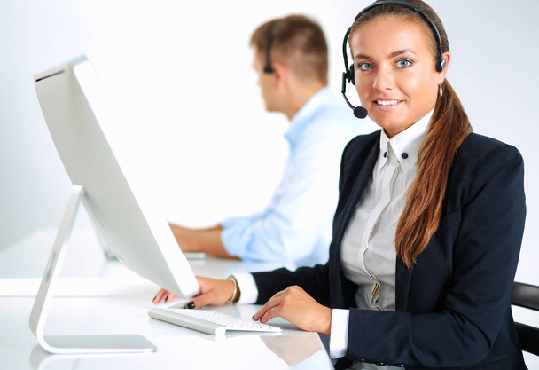 Szczęśliwa kobieta nosi słuchawki i siedzi na biurku - Zdjęcie, obraz