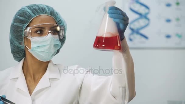 Медичний вчений проводить біохімічні дослідження, хімічна реакція в колбі
 - Кадри, відео