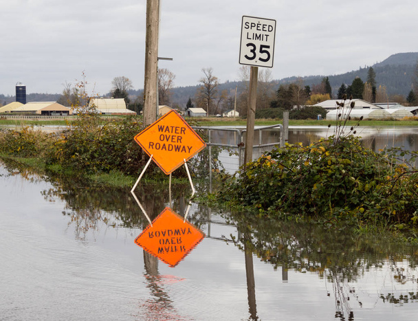 Zaplavená silnice s vodou přes silnici znamení - Fotografie, Obrázek