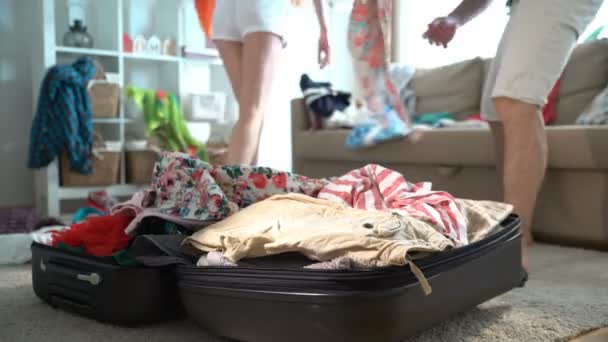 A couple is haphazardly packing and trying to close a chock-full suitcase. Time lapse. - Filmati, video