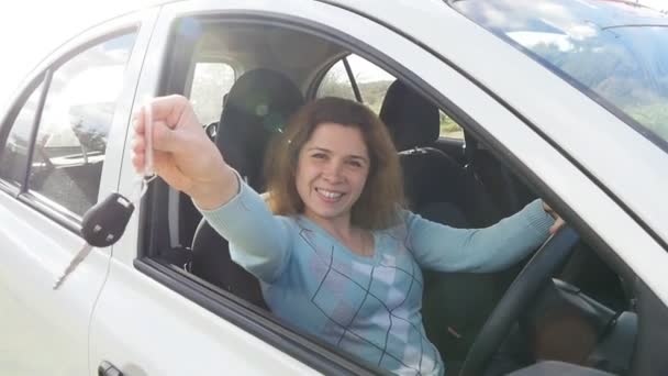 Szczęśliwa młoda kobieta kierowca kluczyki do samochodu jej nowy samochód - Materiał filmowy, wideo