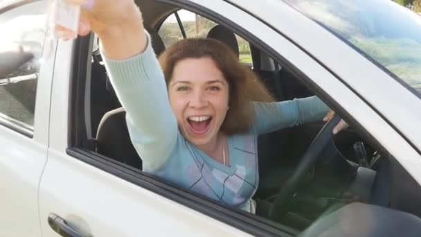 新しい車のキーを示す幸せな女 - 映像、動画