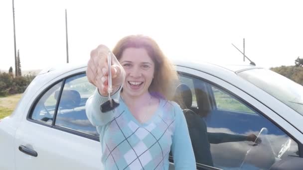 Szczęśliwa młoda kobieta kierowca kluczyki do samochodu jej nowy samochód - Materiał filmowy, wideo