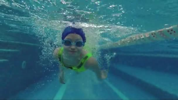 Het kind is zwemmen in het zwembad. Onderwater fotograferen - Video