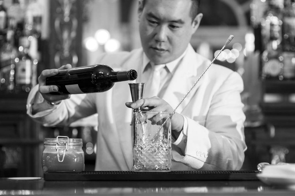 Kiinalainen baarimikko tekee cocktailia yökerhossa.
. - Valokuva, kuva