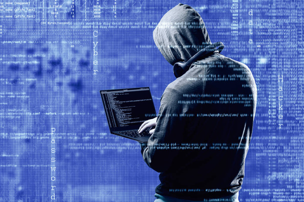 Concepto de crimen en Internet. Peligroso hacker, con sudadera con capucha y fondo azul oscuro digital alrededor, robando sus datos
. - Foto, imagen