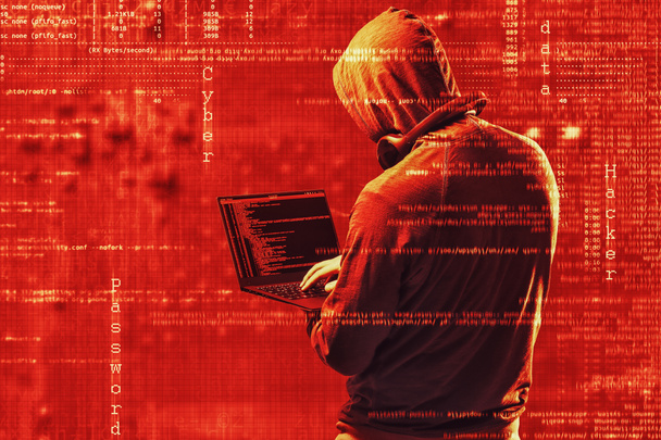 Internet crime concept. Dangerous hacker, in hoodie shirt and dark red digital background around, stealing your data. - Photo, Image