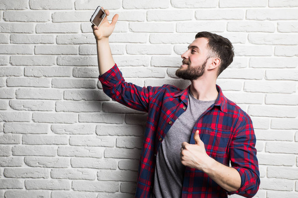 schöner junger Mann in lässiger Kleidung macht Selfie - Foto, Bild