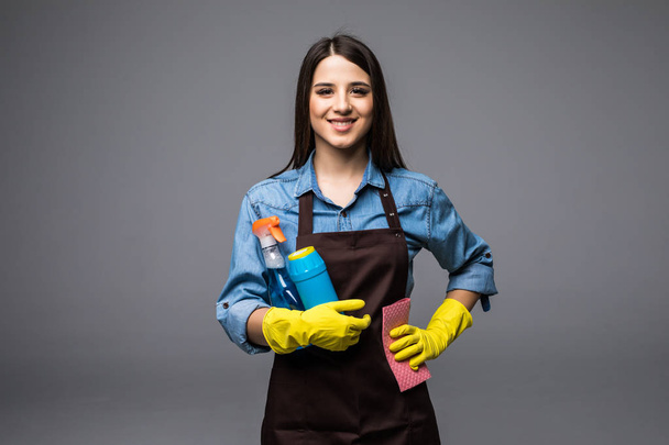 Femme souriante tenant une bouteille de chimie pour nettoyer la maison. Portrait isolé
. - Photo, image