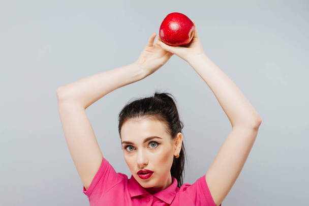 Een mooie vrouw nemen van een hap uit een rode appel. - Foto, afbeelding