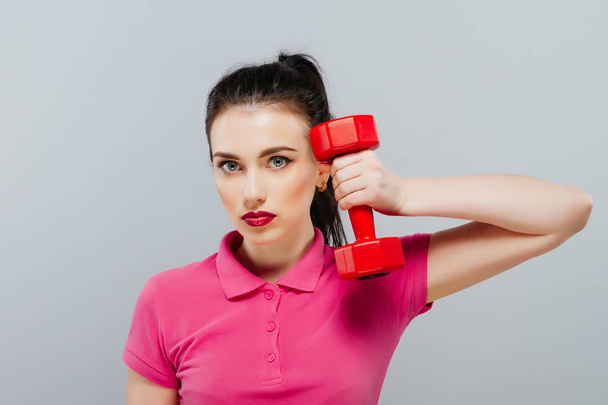 Portrait of young woman posing with dumbbells in gym. Sport life - Foto, Bild