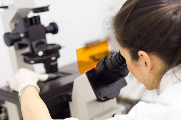 Vědecko-výzkumný pracovník zabývající se mikroskopem v genetické vědecké laboratoři. - Fotografie, Obrázek