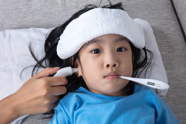 asiatische chinesische Mädchen bekommen Messung für Fieber gemäßigt - Foto, Bild