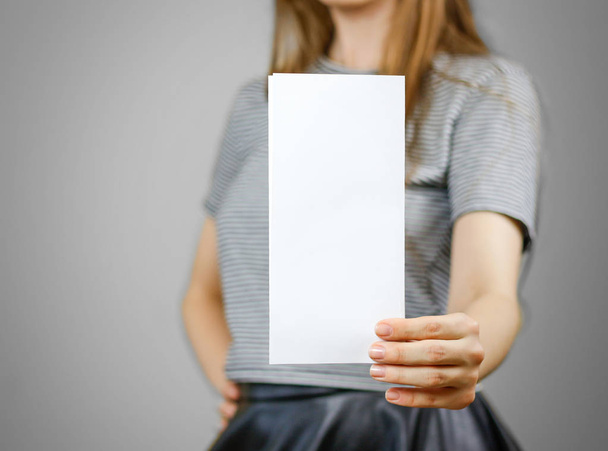 Woman showing blank white flyer paper. Leaflet presentation. Pam - Фото, изображение