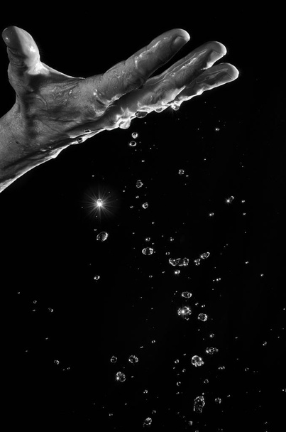 Man's hand and water splashing. - Zdjęcie, obraz