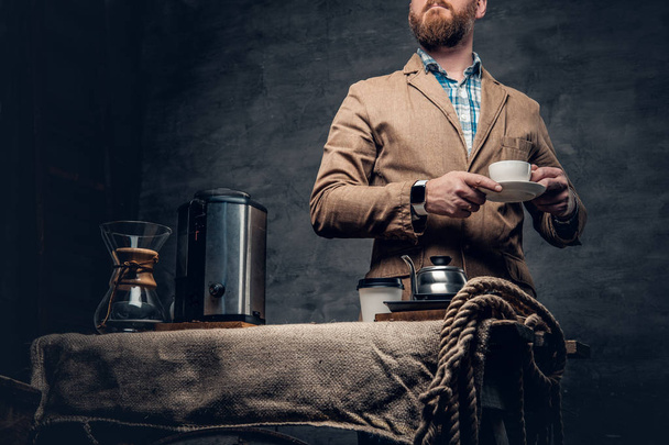 Bearded male near a table with coffee machine - Photo, image