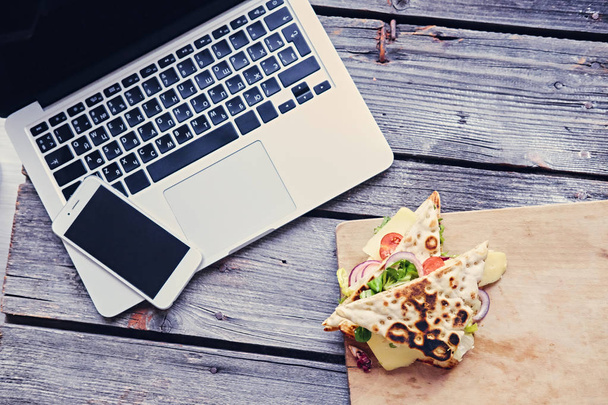 Laptop, smartphone and pita sandwich - 写真・画像