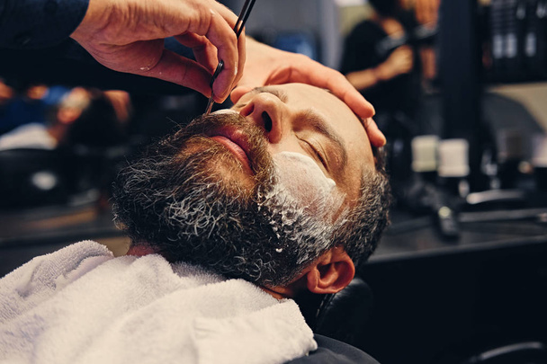Borbély borotválkozás, szakállas férfi, egy éles borotva - Fotó, kép