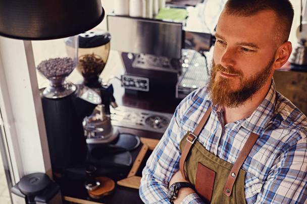 Бородатий продавець кави на своєму робочому місці
 - Фото, зображення