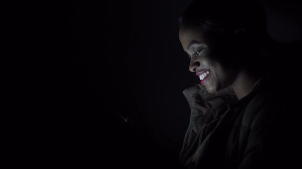Μαύρο γυναίκα cheks το τηλέφωνό της στο σκοτάδι - Πλάνα, βίντεο