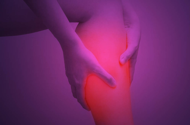 Young woman holding her calf muscle in pain with red highlighted, Isolated on white background - Photo, Image