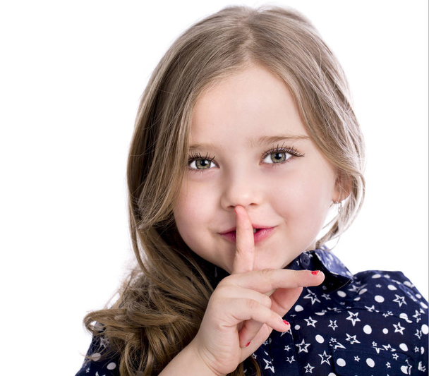 Beautiful Little girl has put forefinger to lips as sign of sile - Foto, Imagen