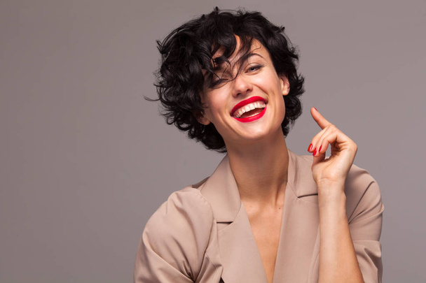 Happy laughing feminist woman with curly Hair on brown Background. Copy Space - 写真・画像