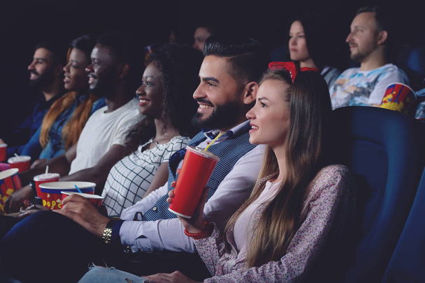 Ομάδα ανθρώπων βλέποντας ταινία στην σύγχρονη κινηματογραφική αίθουσα. - Φωτογραφία, εικόνα