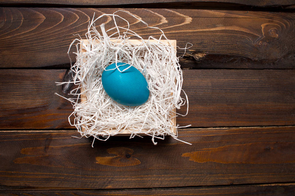 Pollo blu, uovo dipinto per la festa di Pasqua in una scatola su uno sfondo resistente alle intemperie in legno
 - Foto, immagini