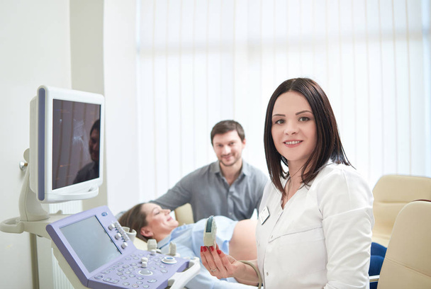 Loving couple attending doctor for pregnancy ultra sound procedu - Valokuva, kuva