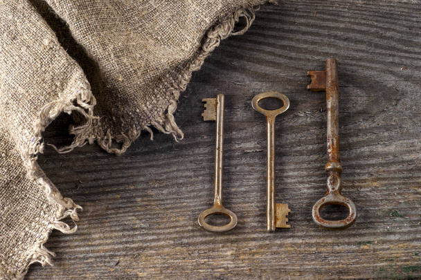 Old vintage books and keys on table on rustic wooden background. - Foto, Bild