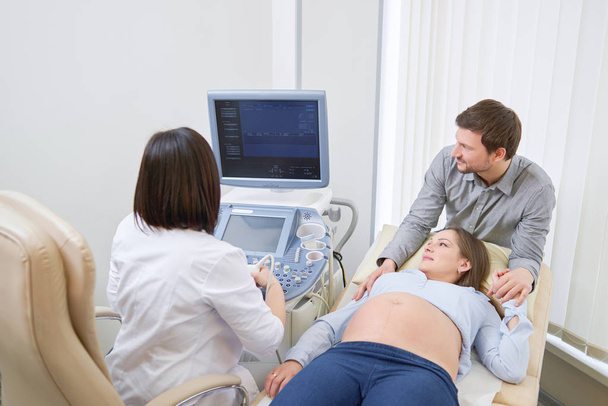 Loving couple attending doctor for pregnancy ultra sound procedu - Foto, immagini