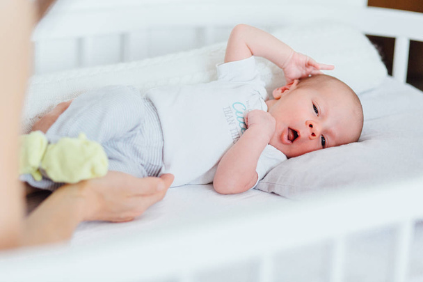 Новорожденный ребенок на кровати
. - Фото, изображение