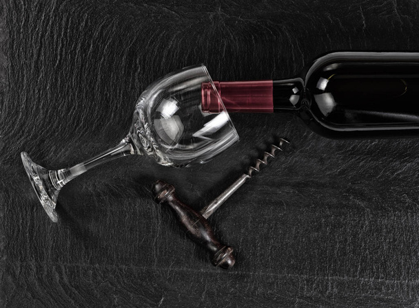 Overhead view of vintage corkscrew with red wine bottle and drin - Foto, Imagen