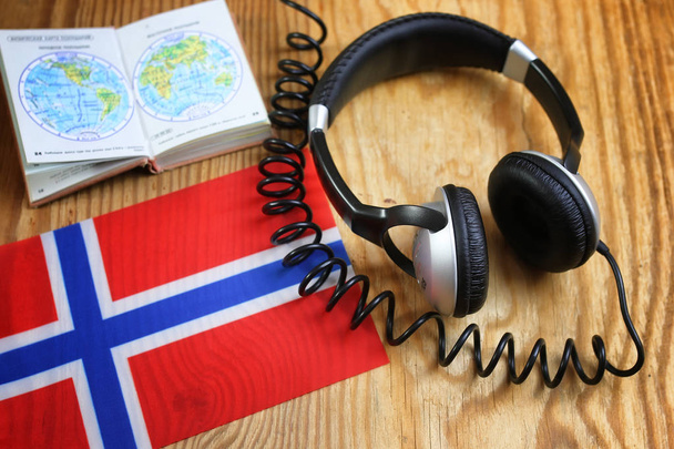 auriculares y bandera del idioma del curso en una mesa
 - Foto, Imagen