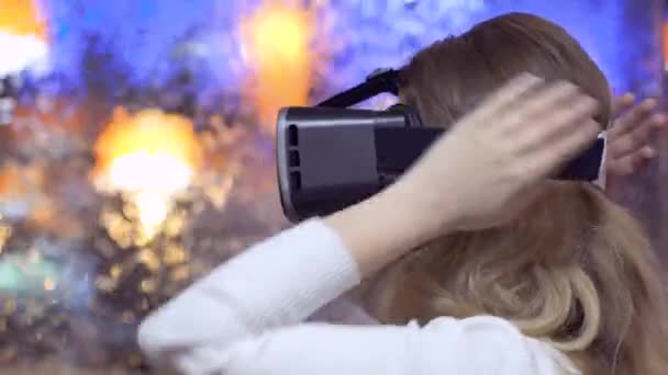 woman puts on and uses virtual reality glasses on an abstract background - Footage, Video