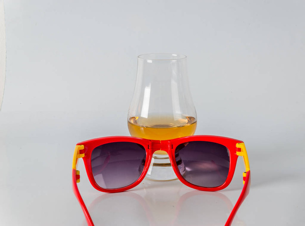 νόστιμα ενιαίου malt ουίσκι γυαλί με γυαλιά ηλίου για ένα λευκό β - Φωτογραφία, εικόνα