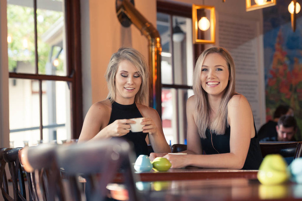 blonde females drinking coffee - Фото, зображення