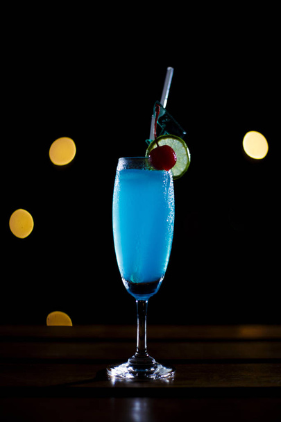 blauer Cocktail im Glas auf dunklem Hintergrund - Foto, Bild