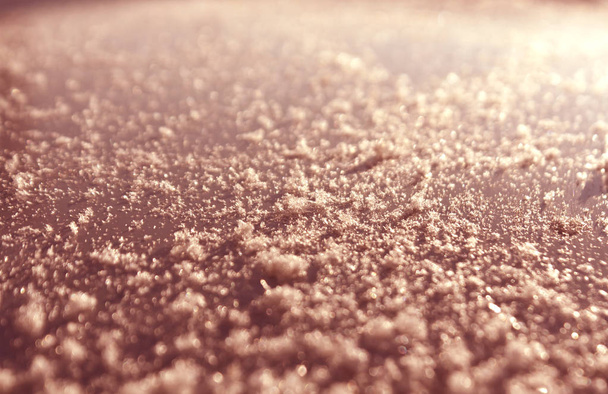 Snow on red toned metal car surface with blur effect.  - Фото, изображение